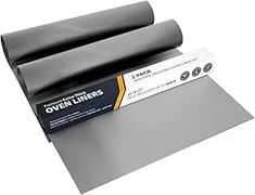 a roll of black vinyl on top of a piece of gray paper with an adhesive sticker