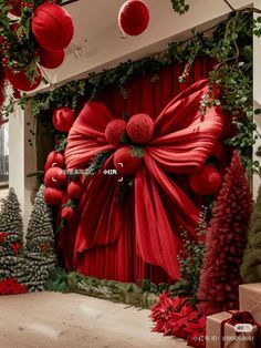 the red curtain is decorated with poinsettis and greenery as well as decorations