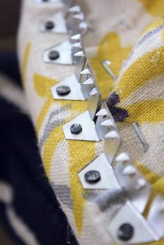 there are several metal rivets on the fabric that has been stitched together