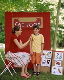 a little boy and woman standing in front of a tattoo booth