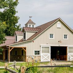 a large white barn sitting next to a lush green field