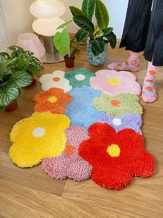 colorful rugs on the floor in front of potted plants and houseplants