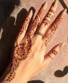 a woman's hand with henna tattoos on it