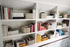 a bookshelf filled with lots of books on top of white shelving units