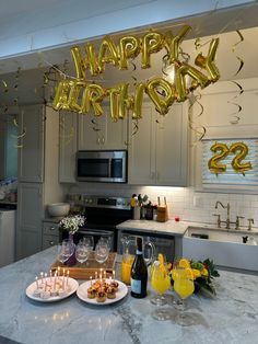 a kitchen counter topped with plates of food and balloons that say happy birthday to everyone