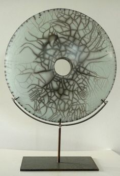 a glass plate sitting on top of a metal stand in front of a white wall