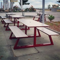 there are many benches lined up on the side of the street in front of an empty parking lot