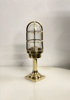 an old fashioned brass lamp on a white table