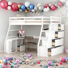 a loft bed with balloons and confetti on the floor in front of it