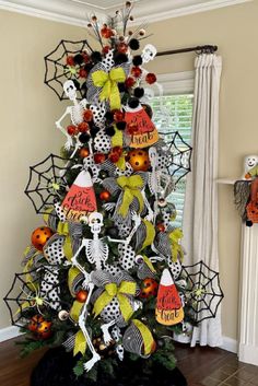 a decorated christmas tree in the corner of a living room with halloween decorations on it