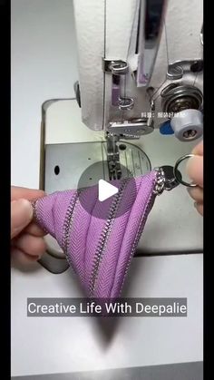 someone is using a sewing machine to sew something with purple fabric on the side