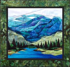 a quilted landscape with trees and mountains in the background, along with blue water