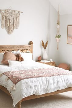 a bedroom with a bed, nightstands and pictures on the wall above it is decorated in pink and white