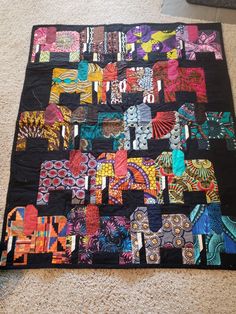 a colorful quilt is laying on the floor with it's edges cut out to look like animals