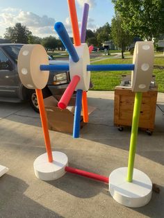 several different colored toothbrushes are on display in front of a car parked by the curb