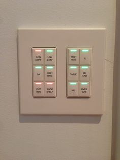 a white light switch with green and red lights on the buttons in front of it