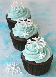 three chocolate cupcakes with blue frosting and snowflakes