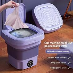 a person is cleaning a purple trash can with a cloth in it and the lid open