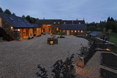 a large stone building with lots of windows and lights on it's front yard