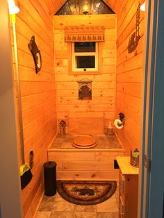 a bathroom with wooden walls and flooring in a cabin style home or office area