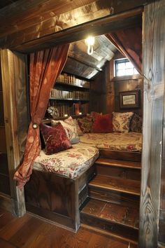 a bed sitting inside of a bedroom next to a wooden floor covered in bookshelves