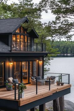 a house that is sitting on top of a wooden deck next to water and trees