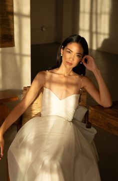 a woman in a white dress sitting on a chair