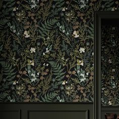 the wallpaper in this room is dark green and has flowers on it, along with leaves