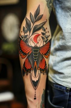 a person with a tattoo on their arm holding a red and black butterfly in the center