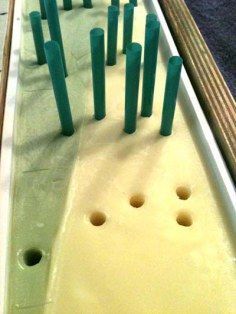 a row of bowling pins sitting on top of a white table next to a blue rug