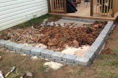 a backyard area with rocks and dirt in the ground next to a deck that is being built