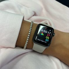 an apple watch on someone's arm with a chain attached to the wristband