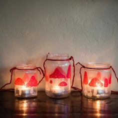 three mason jars with fairy lights in them sitting on a table next to each other