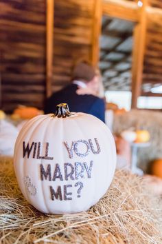 a white pumpkin with the words will you marry me written on it sitting in hay