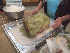 a woman is preparing food on tin foil in the kitchen with other dishes and utensils