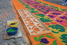 colorful rugs and buckets on the ground next to each other