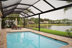 a swimming pool with an enclosed patio area next to it