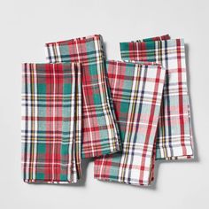 four red and green plaid napkins sitting on top of each other