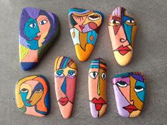 six painted rocks with faces on them