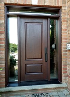 a wooden door with glass on the side of a brick building