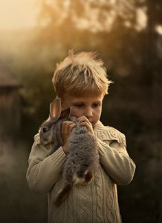 a young boy holding a stuffed animal in his hands