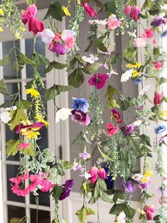 colorful flowers hanging from the side of a building