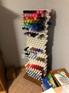 a stack of crayons sitting on top of a wooden table next to a wall