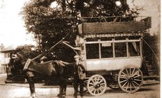 an old photo of a horse pulling a wagon with a man standing next to it