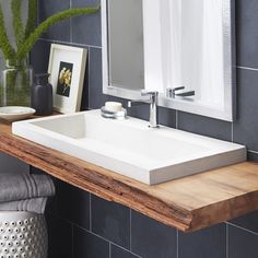 a bathroom sink sitting on top of a wooden counter