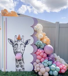 a giraffe themed birthday party with balloons in the shape of a pyramid and an umbrella