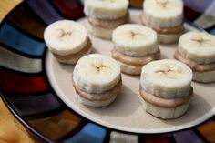 a white plate topped with mini sandwiches covered in banana slices