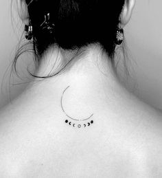 the back of a woman's neck with three small phases on her left shoulder