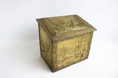 an ornate gold box with figures on it