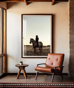 a man riding on the back of a horse next to a brown chair and table